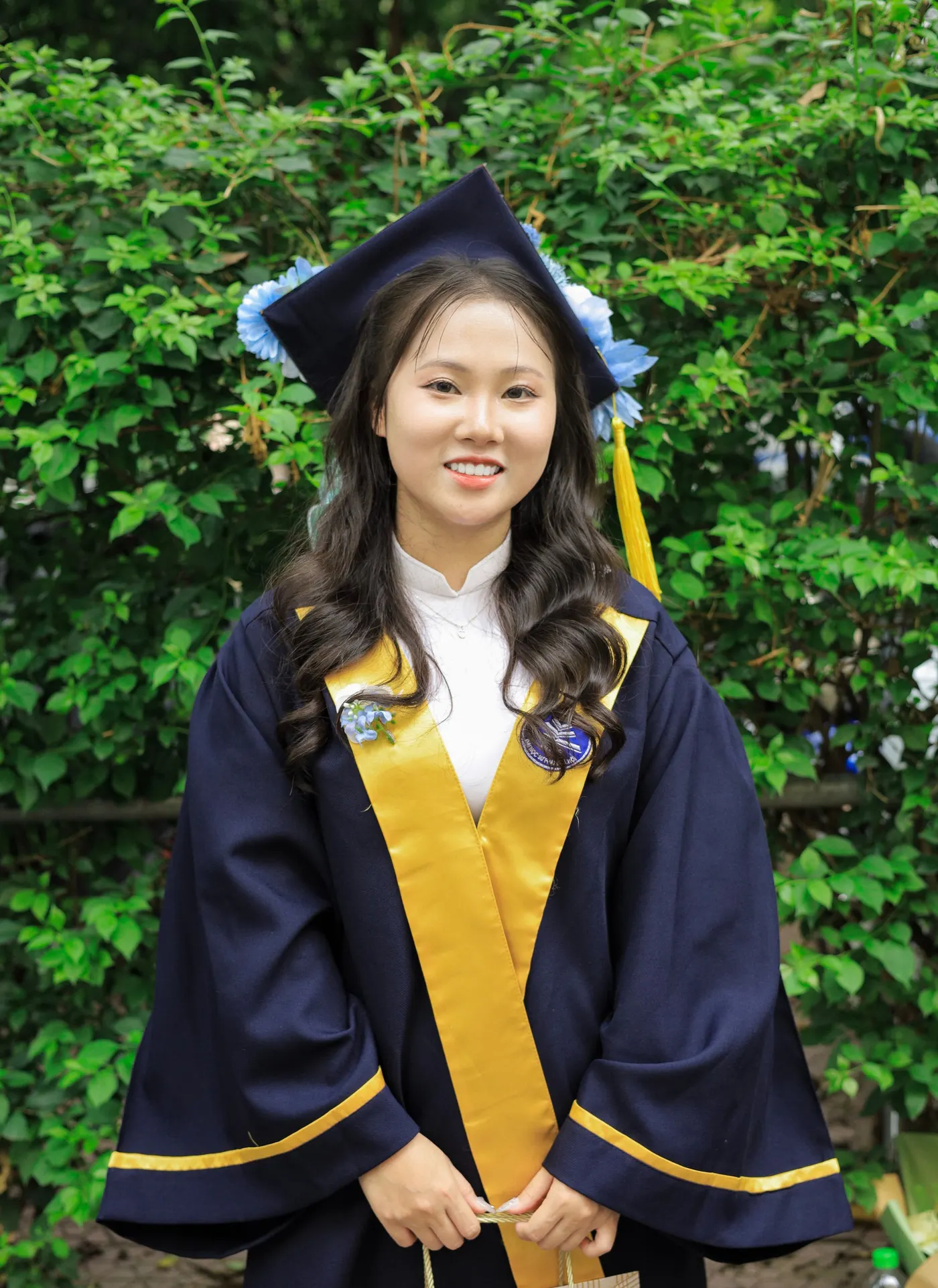 Smiling graduate in cap and gown outdoors